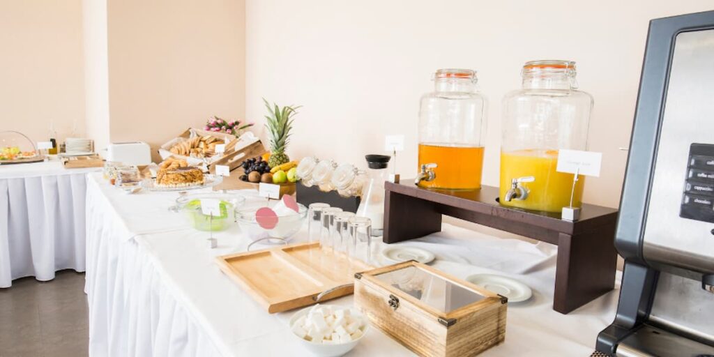 Imagem de uma mesa de café da manhã no hotel com diversas opções de sucos e comidas