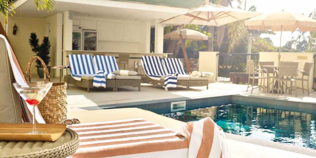 Imagem de uma piscina de hotel com diversas toalhas nas cadeiras