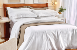 Quarto de Airbnb com cama organizada com enxoval.